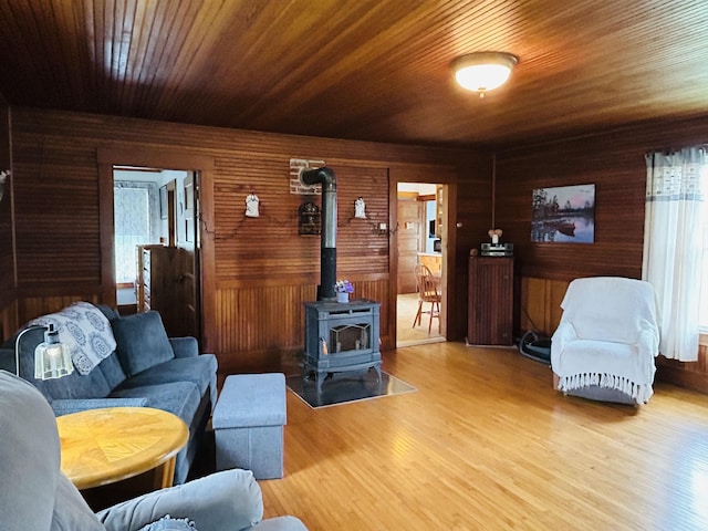 6998 River Rd, Lemington, VT 05903 - living room featuring a wood stove, wood finished floors, wood walls, and wooden ceiling