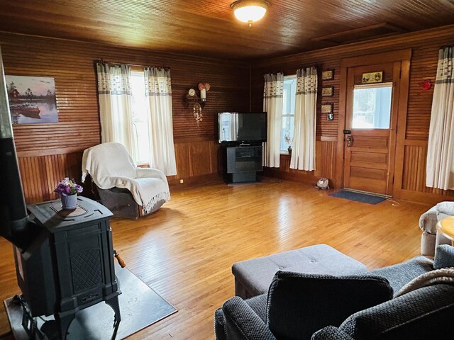 6998 River Rd, Lemington, VT 05903 - living room featuring healthy amount of natural light, wood finished floors, wood ceiling, wooden walls, and a wood stove