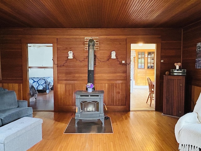 6998 River Rd, Lemington, VT 05903 - living room featuring a wood stove, wood finished floors, wooden ceiling, and wooden walls
