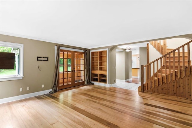 379 Swallow Hill Rd, Pownal, VT 05261 - unfurnished living room with arched walkways, french doors, hardwood / wood-style flooring, and baseboards