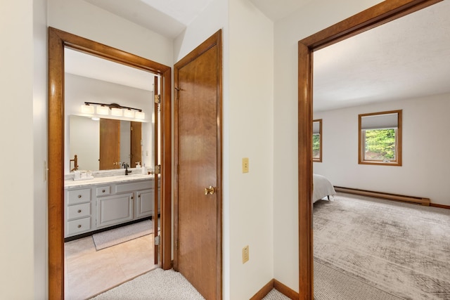 11 Village W Dr Unit 5, Bristol, NH 03222 - hall with baseboard heating, a sink, light carpet, and baseboards