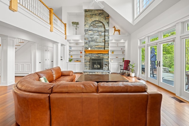 543 Lower Hollow Rd, Dorset, VT 05251 - living room featuring a towering ceiling, healthy amount of natural light, wood-type flooring, a stone fireplace, and a ceiling fan