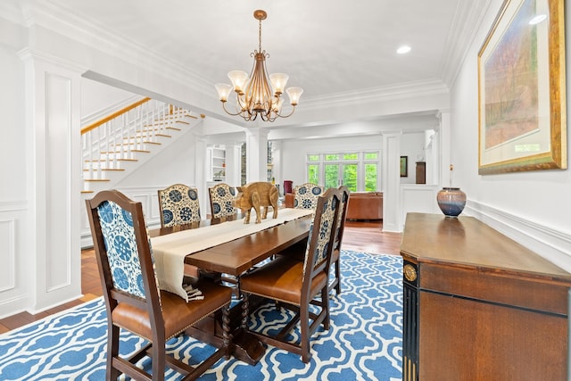543 Lower Hollow Rd, Dorset, VT 05251 - dining area with ornate columns, a decorative wall, wood finished floors, a chandelier, and crown molding