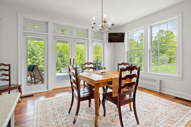 543 Lower Hollow Rd, Dorset, VT 05251 - dining room featuring radiator heating unit, a chandelier, light wood-type flooring, french doors, and baseboards