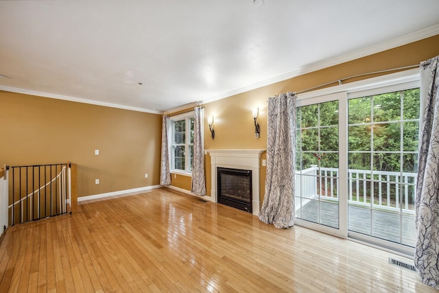 60 Barrington Ave Unit 60, Nashua, NH 03062 - unfurnished living room with plenty of natural light, ornamental molding, light wood-type flooring, baseboards, and a glass covered fireplace