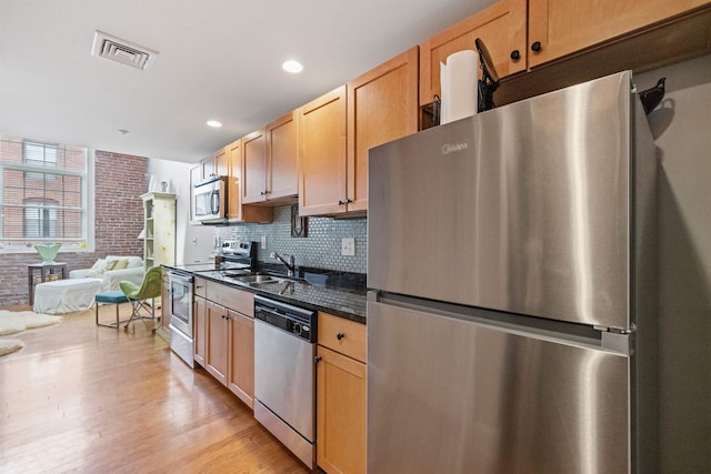 48 Landing Ln Unit 15, Laconia, NH 03246 - kitchen featuring appliances with stainless steel finishes, a sink, backsplash, light wood-style floors, and open floor plan