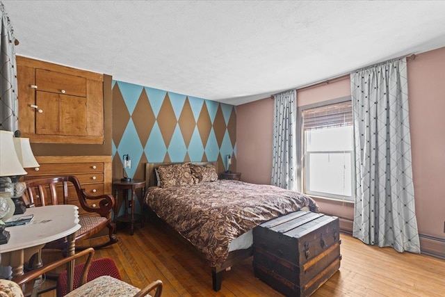 1460 Main St, Waitsfield, VT 05673 - bedroom with wallpapered walls, an accent wall, hardwood / wood-style floors, and a textured ceiling