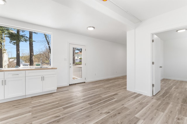 15 Highland Ave, Claremont, NH 03743 - unfurnished living room featuring a sink, light wood-style flooring, and baseboards