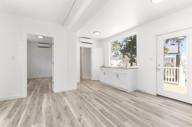 15 Highland Ave, Claremont, NH 03743 - unfurnished bedroom featuring a wall mounted AC, access to exterior, and light wood-style flooring