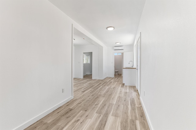 15 Highland Ave, Claremont, NH 03743 - corridor with a sink, light wood finished floors, baseboards, and an AC wall unit