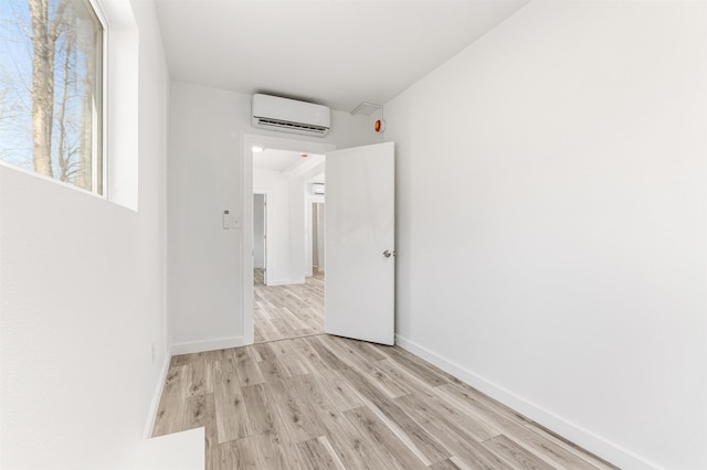 15 Highland Ave, Claremont, NH 03743 - empty room featuring an AC wall unit, light wood-style floors, and baseboards