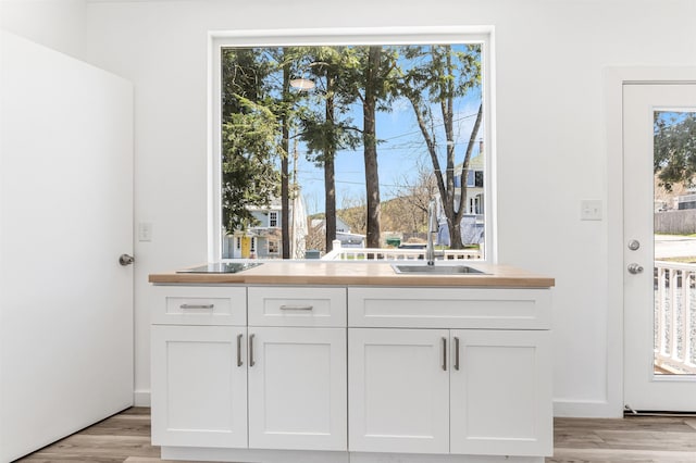 15 Highland Ave, Claremont, NH 03743 - kitchen featuring white cabinets, light wood-type flooring, and a sink