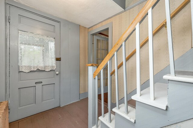 31 Prospect St, Franklin, NH 03235 - entrance foyer featuring hardwood / wood-style flooring, stairs, and radiator heating unit