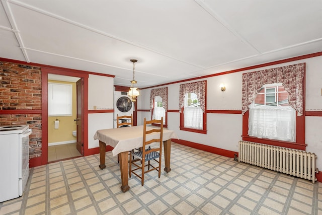 31 Prospect St, Franklin, NH 03235 - dining area with radiator heating unit, stacked washer / drying machine, light flooring, crown molding, and baseboards