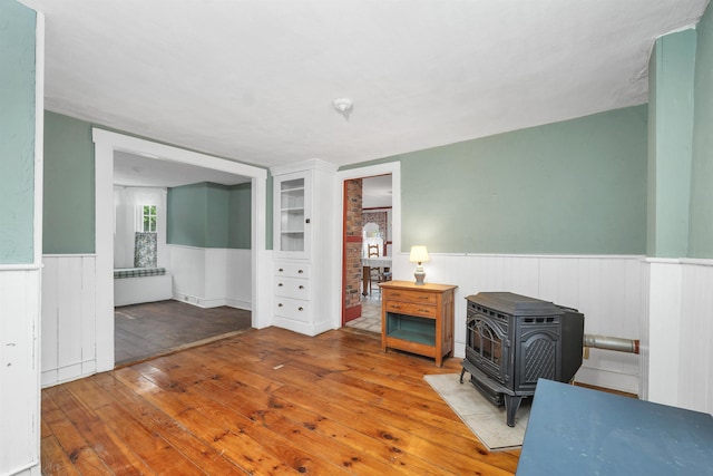 31 Prospect St, Franklin, NH 03235 - spare room featuring a wainscoted wall, hardwood / wood-style flooring, and a wood stove