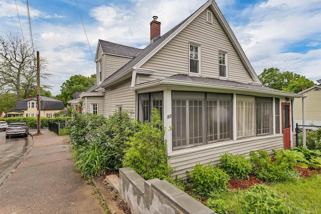 31 Prospect St, Franklin, NH 03235 - view of home's exterior featuring a sunroom, a shingled roof, and a chimney