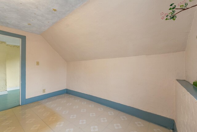 31 Prospect St, Franklin, NH 03235 - additional living space with vaulted ceiling, tile patterned floors, and baseboards