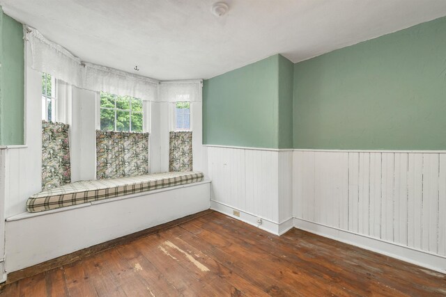 31 Prospect St, Franklin, NH 03235 - spare room featuring a wainscoted wall, hardwood / wood-style floors, wood walls, and a smoke detector
