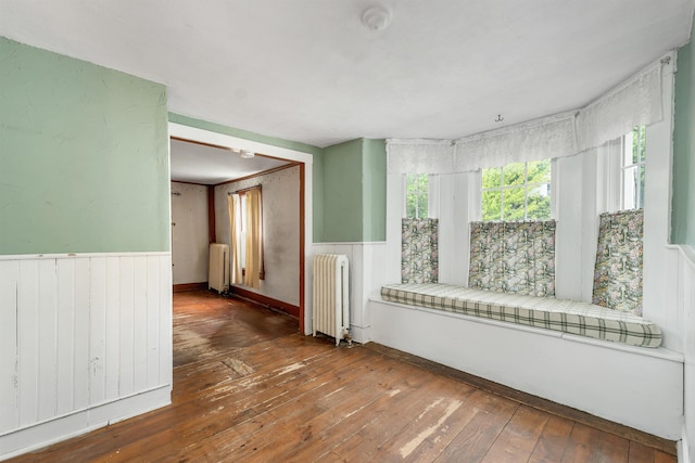 31 Prospect St, Franklin, NH 03235 - unfurnished room featuring radiator, wood-type flooring, a wainscoted wall, and wooden walls