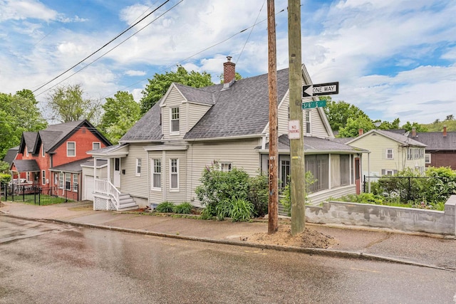 31 Prospect St, Franklin, NH 03235 - view of front of home featuring a chimney, a shingled roof, and a sunroom