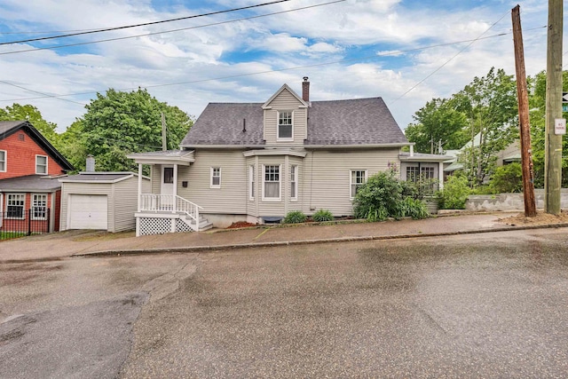 31 Prospect St, Franklin, NH 03235 - cape cod-style house featuring a chimney, an outdoor structure, driveway, and roof with shingles