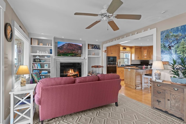 745 Ocean Blvd, Hampton, NH 03842 - living area featuring a glass covered fireplace, ceiling fan, light wood-type flooring, and built in shelves