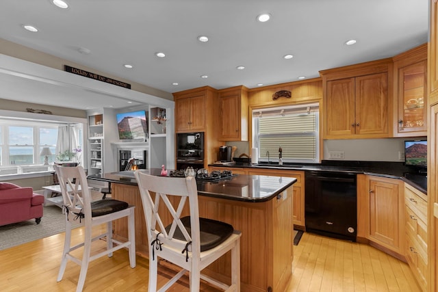 745 Ocean Blvd, Hampton, NH 03842 - kitchen with black appliances, a sink, light wood-style floors, a center island, and a kitchen bar
