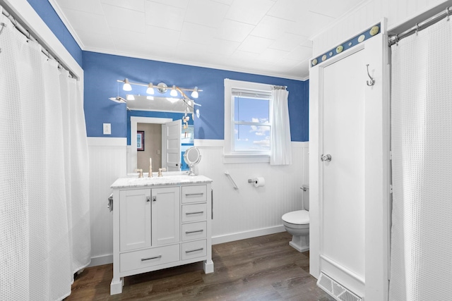 745 Ocean Blvd, Hampton, NH 03842 - full bathroom with wainscoting, ornamental molding, vanity, wood finished floors, and toilet