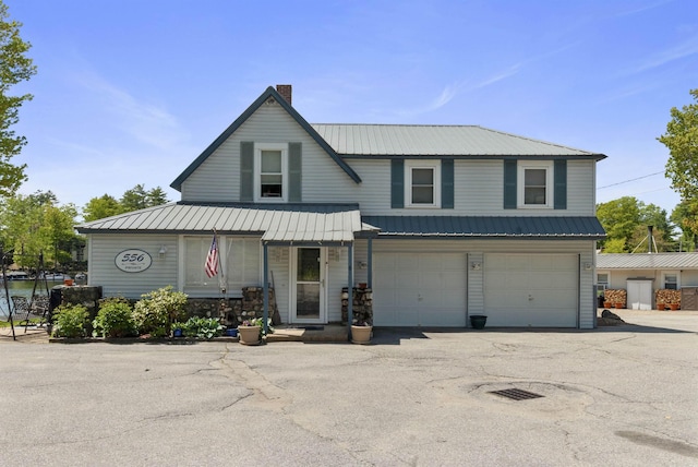 556 Weirs Blvd Unit 6, Laconia, NH 03246 - view of front of house with a chimney, metal roof, a garage, and driveway