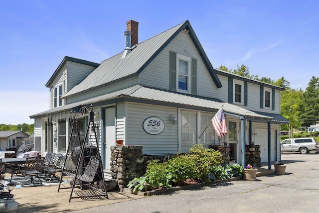 556 Weirs Blvd Unit 6, Laconia, NH 03246 - view of front of home featuring metal roof, a garage, and a chimney