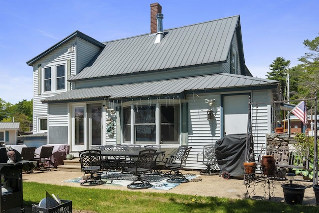 556 Weirs Blvd Unit 6, Laconia, NH 03246 - back of property with a patio, metal roof, and a chimney