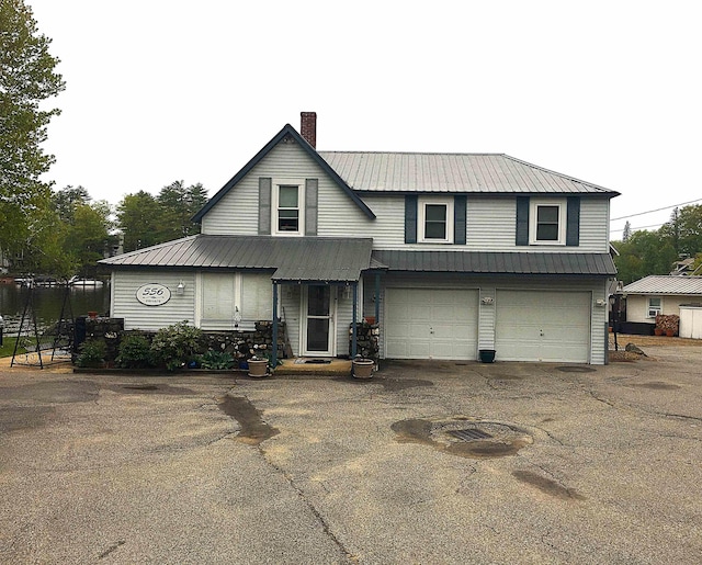 556 Weirs Blvd Unit 6, Laconia, NH 03246 - view of front of home featuring a chimney, metal roof, driveway, and a garage