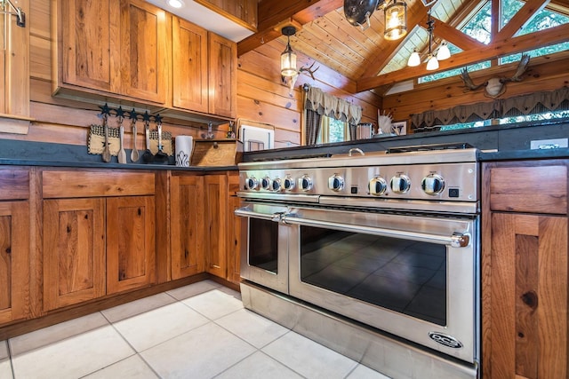 213 Singing Cedars Rd, Orwell, VT 05760 - kitchen with range with two ovens, dark countertops, light tile patterned floors, brown cabinets, and lofted ceiling
