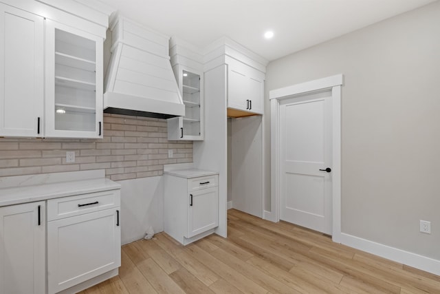 280 Sterling Dr, Laconia, NH 03246 - kitchen with tasteful backsplash, glass insert cabinets, light wood-type flooring, white cabinetry, and baseboards