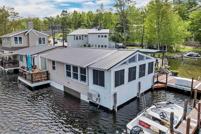 556 Weirs Blvd Unit 4, Laconia, NH 03246 - back of property featuring metal roof, view of scattered trees, a deck with water view, and a cooling unit