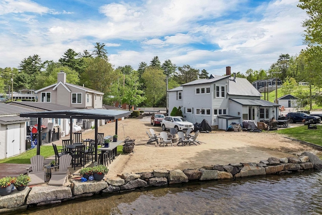 556 Weirs Blvd Unit 4, Laconia, NH 03246 - back of property featuring outdoor dining space, a water view, a chimney, and a patio