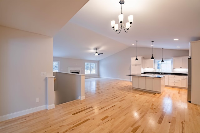 153 Ann Marie Ln, Colchester, VT 05446 - kitchen featuring open floor plan, dark countertops, lofted ceiling, light wood-style flooring, and a chandelier