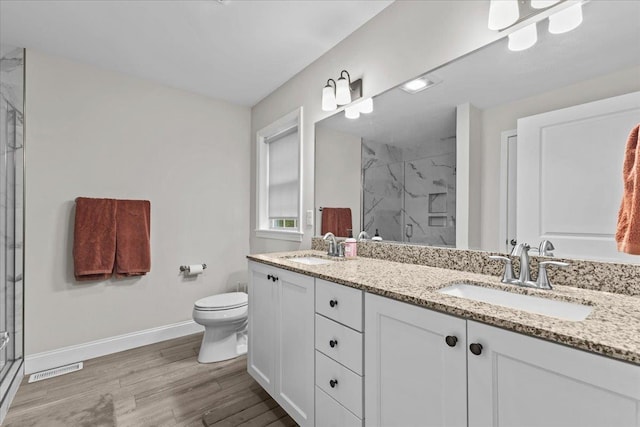153 Ann Marie Ln, Colchester, VT 05446 - full bathroom with a marble finish shower, double vanity, toilet, wood finished floors, and baseboards