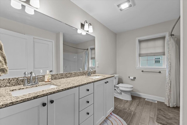 153 Ann Marie Ln, Colchester, VT 05446 - bathroom with baseboards, double vanity, a shower with shower curtain, toilet, and wood finished floors