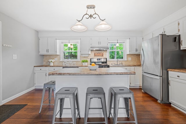 11 Beauchesne Dr, Hooksett, NH 03106 - kitchen with stainless steel appliances, under cabinet range hood, a kitchen bar, and tasteful backsplash