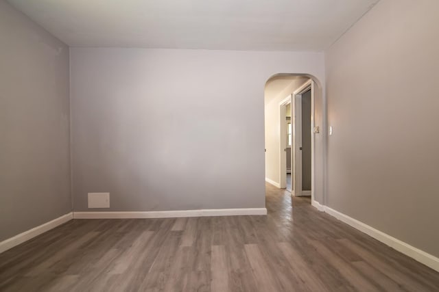 82 S Jewett St, Manchester, NH 03103 - unfurnished room featuring arched walkways, wood finished floors, and baseboards