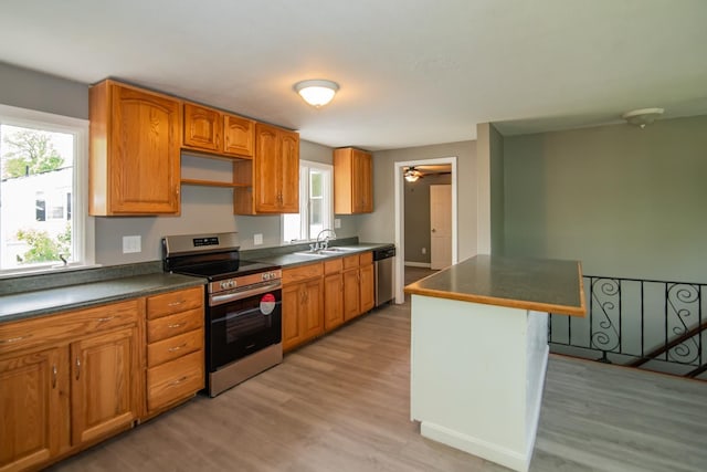 82 S Jewett St, Manchester, NH 03103 - kitchen with appliances with stainless steel finishes, a sink, light wood-style flooring, dark countertops, and brown cabinetry