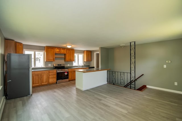 82 S Jewett St, Manchester, NH 03103 - kitchen with appliances with stainless steel finishes, a sink, light wood finished floors, and baseboards