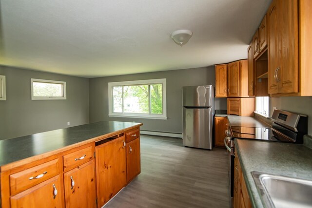 82 S Jewett St, Manchester, NH 03103 - kitchen with stainless steel appliances, baseboard heating, healthy amount of natural light, and brown cabinets