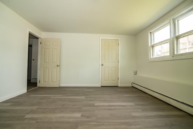 82 S Jewett St, Manchester, NH 03103 - unfurnished bedroom featuring a baseboard radiator, baseboards, and wood finished floors