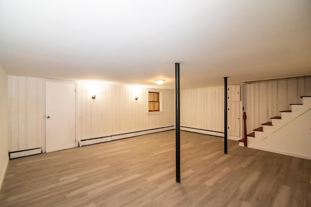 82 S Jewett St, Manchester, NH 03103 - finished below grade area featuring wood finished floors, stairway, and a baseboard radiator