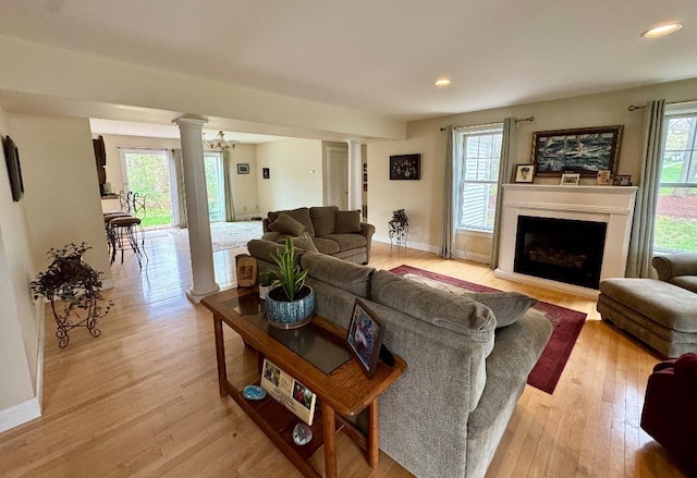 1 Stannard Dr, Essex, VT 05452 - living area with decorative columns, light wood-style flooring, recessed lighting, a fireplace, and baseboards