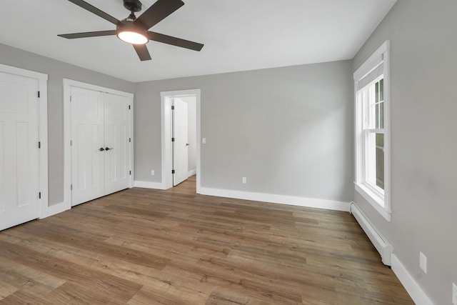 10 Call Rd, Webster, NH 03303 - unfurnished bedroom featuring a baseboard heating unit, baseboards, wood finished floors, and ceiling fan
