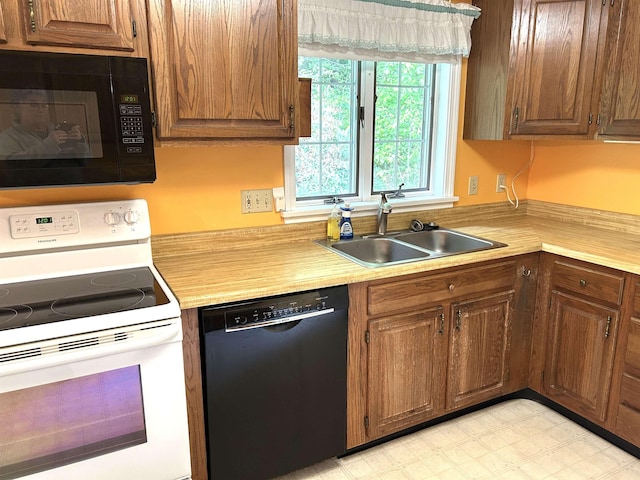 34 Hampshire Cir, Brattleboro, VT 05301 - kitchen with black appliances, a sink, light countertops, and brown cabinets
