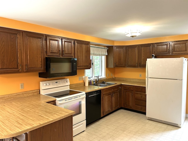 34 Hampshire Cir, Brattleboro, VT 05301 - kitchen with black appliances, a sink, a peninsula, and light countertops